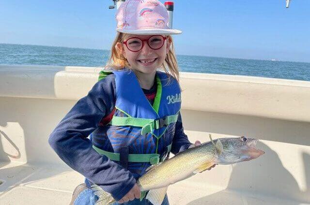 Young girl holding fish